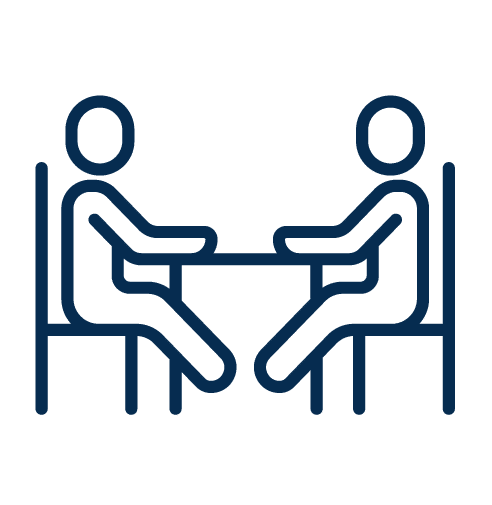 Two person sitting across the table discussing something